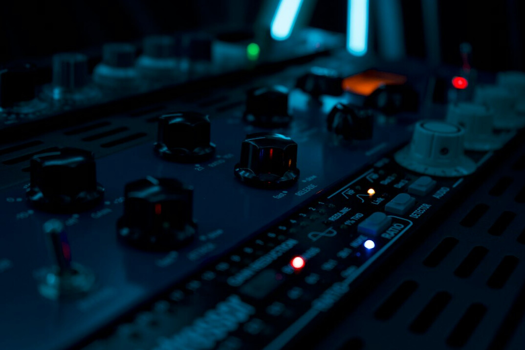 Audio mixing console with faders and knobs